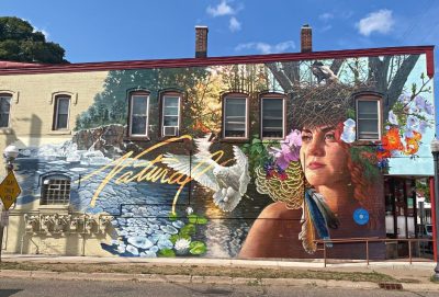 "Natural" mural depicts mother nature surrounded by birds, trees, a waterfall, flowers and a nest crown
